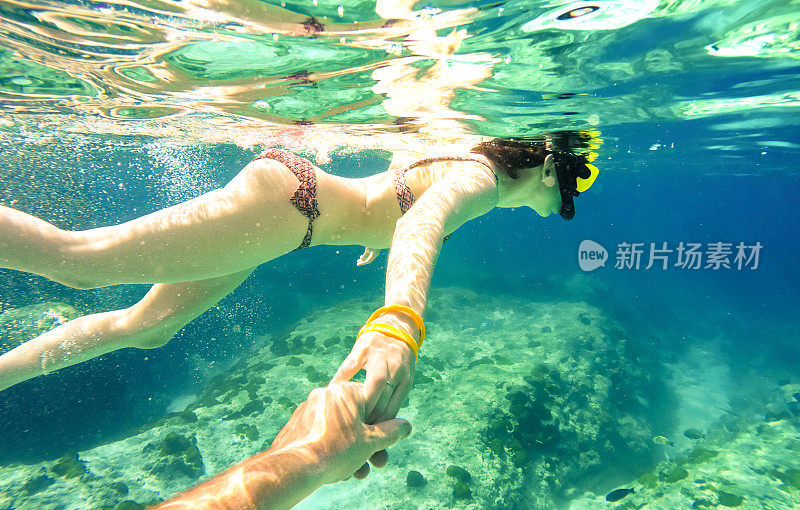 浮潜夫妇游泳一起在热带海洋跟我的构图-浮潜旅游在异国情调的潜水场景-有趣的旅游概念与活跃的女孩水下-软焦点due water density